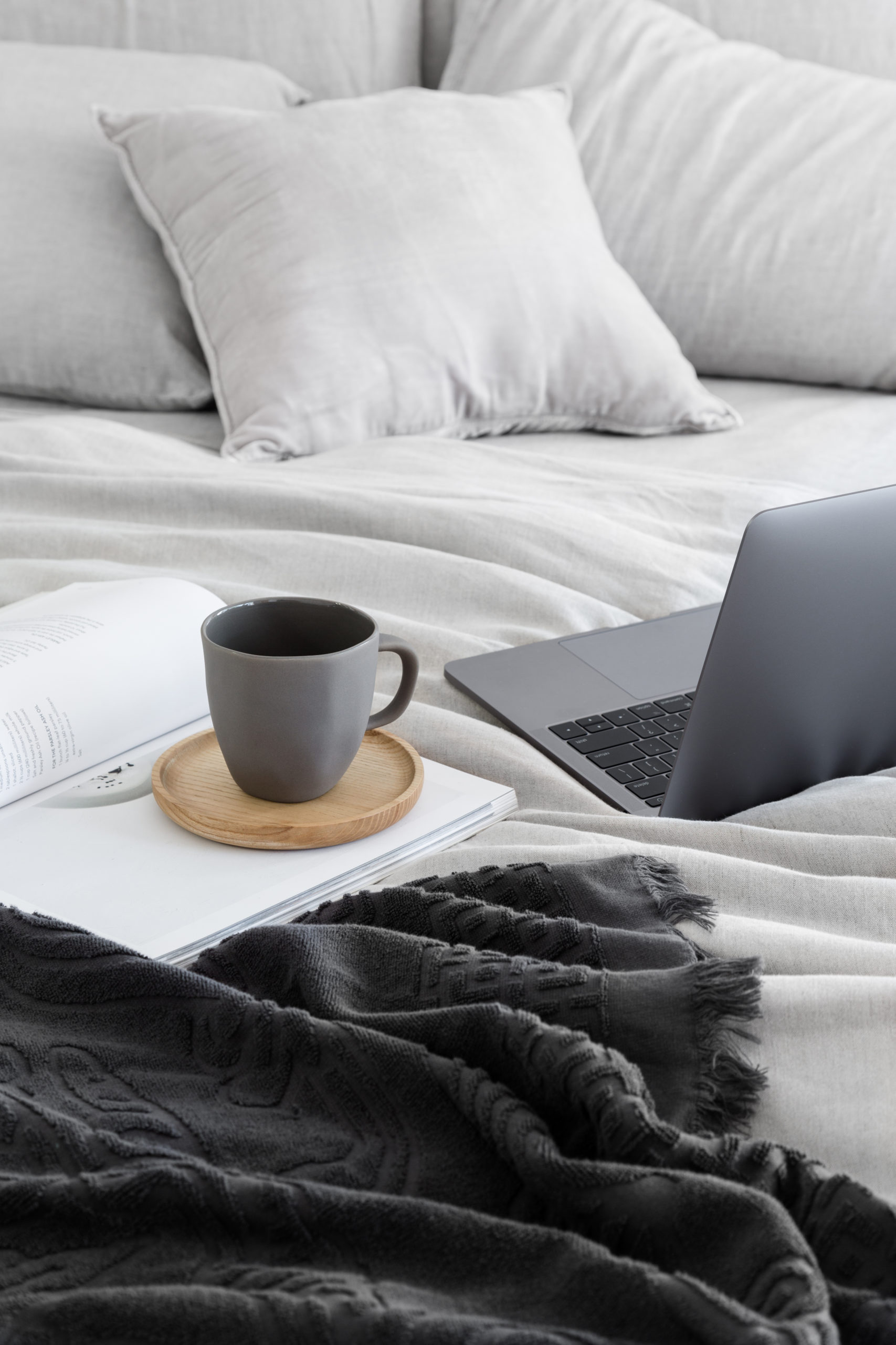 laptop on bed with coffee mug